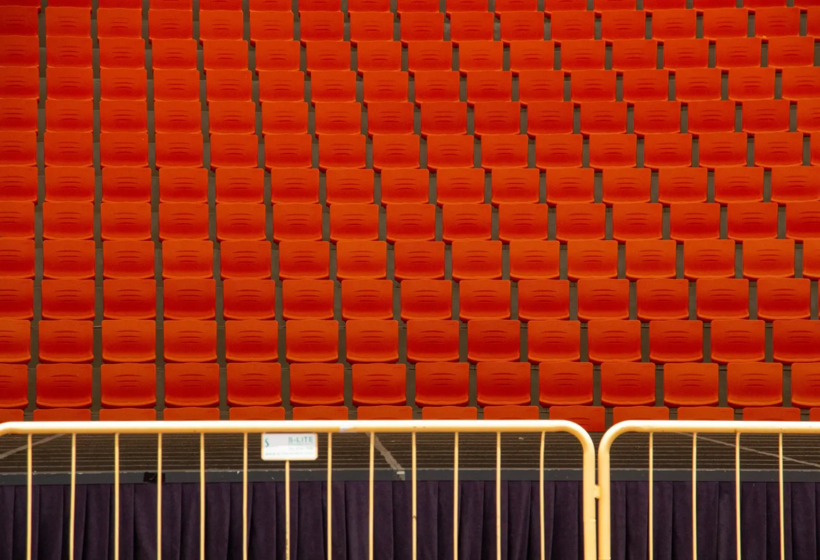 Rows of red auditorium seats with repetitive patterns create a striking visual texture.